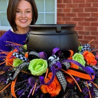 Wisp & Wonder Designs creator showcasing a handcrafted Halloween cauldron centerpiece with premium florals, designer ribbon, and whimsical Halloween decor for tables, mantels and entryways.