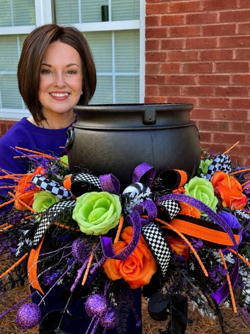 Wisp & Wonder Designs creator showcasing a handcrafted Halloween cauldron centerpiece with premium florals, designer ribbon, and whimsical Halloween decor for tables, mantels and entryways.