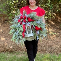 Handmade winter cardinal wreath with white lantern, frosted greenery, berries, red bow and rustic grapevine base