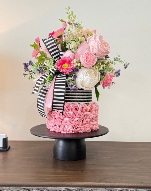 Pink floral cake centerpiece with black and white striped accents and ribbons by Wisp and Wonder Designs