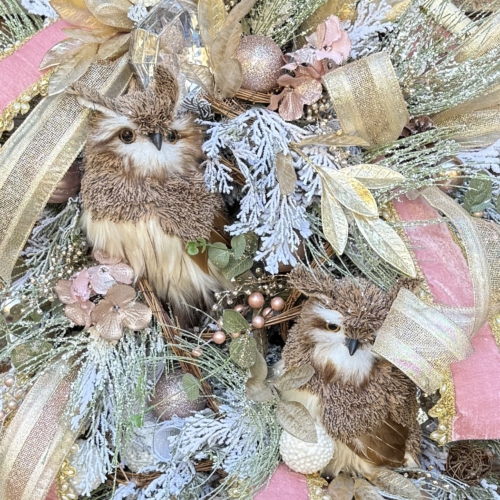 Close up of owl centerpiece with frosted greenery and winter florals.