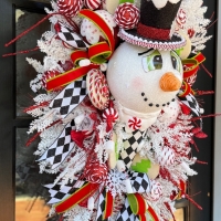Holiday swag with candy and snowman on black door