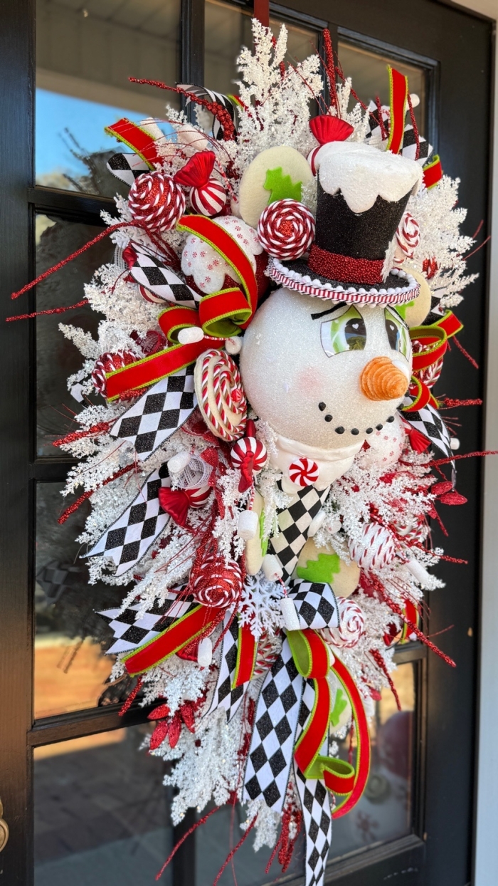 Holiday swag with candy and snowman on black door