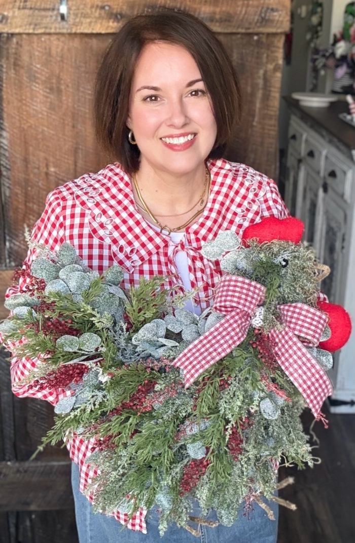 Michelle of Wisp and Wonder Designs holding the Christmas chicken wreath