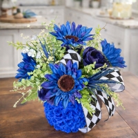 Styled tabletop using cobalt blue stacked design with sunflowers and greenery.