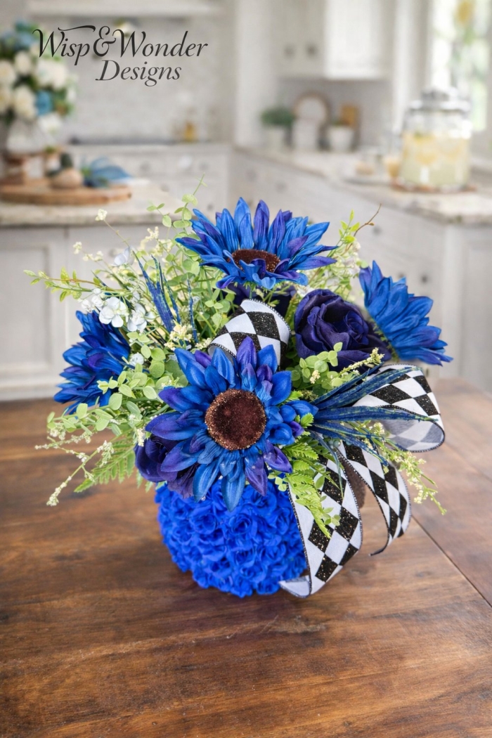 Styled tabletop using cobalt blue stacked design with sunflowers and greenery.