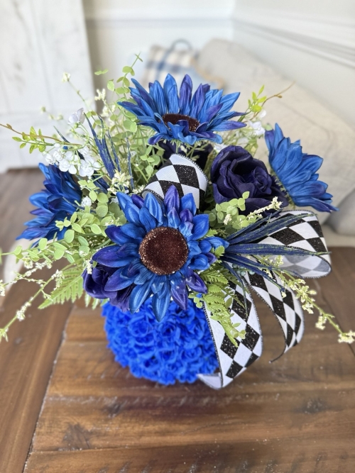 Bold blue floral arrangement with black and white ribbon detail.