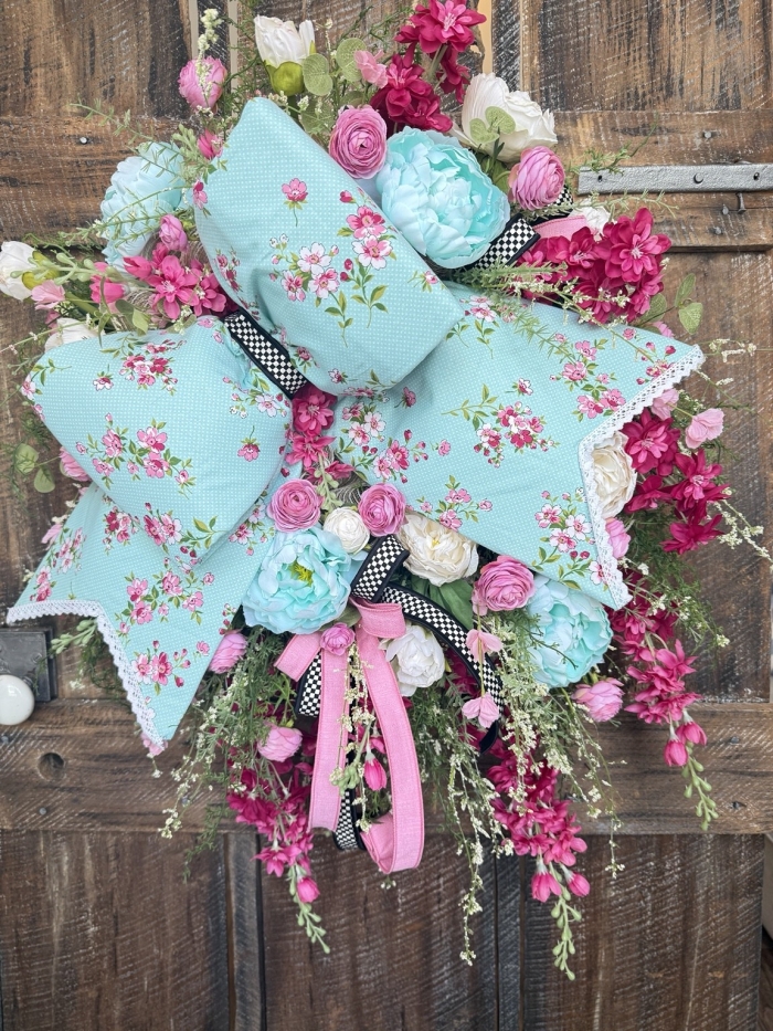 Full design of handmade spring floral wreath with aqua bow and vibrant pink flowers