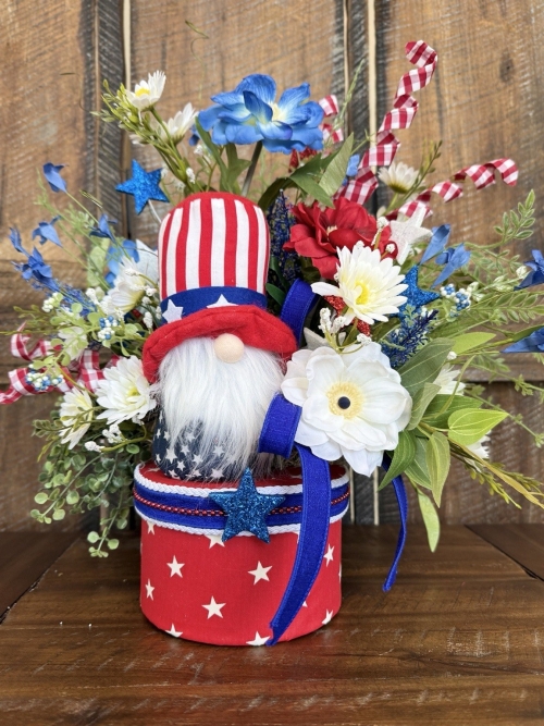 Patriotic gnome centerpiece with red white and blue florals greenery and handmade star container.