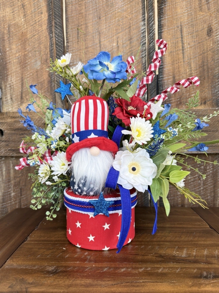 Handmade patriotic gnome centerpiece with red white and blue flowers stars and decorative container