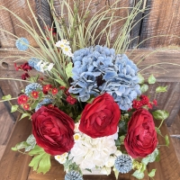 summer floral centerpiece with red blooms, blue flowers, white florals and greenery