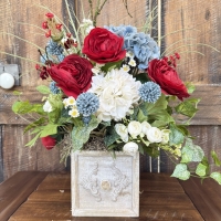 Rustic drawer floral arrangement with red blue and white flowers