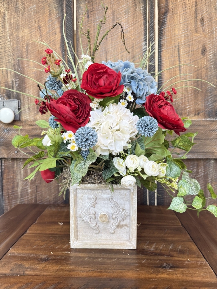 Rustic drawer floral arrangement with red blue and white flowers