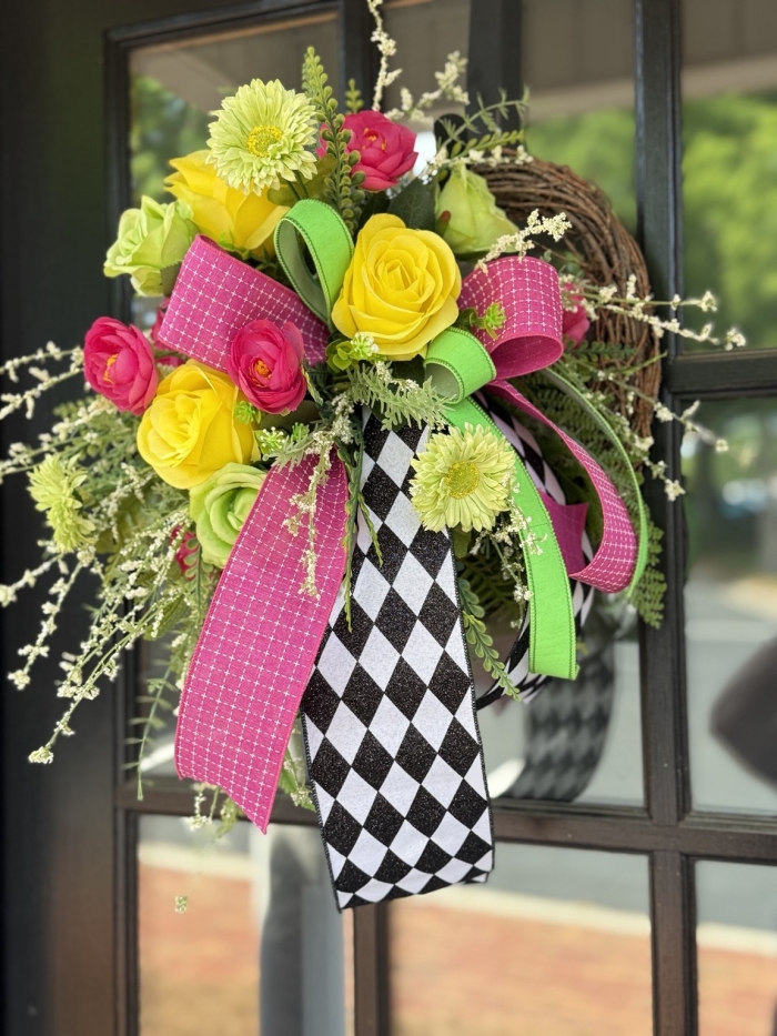 Handmade harlequin mini wreath with pink ribbon, lime green ribbon and yellow flowers