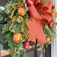 Angled view of luxury orange peony grapevine wreath on front door