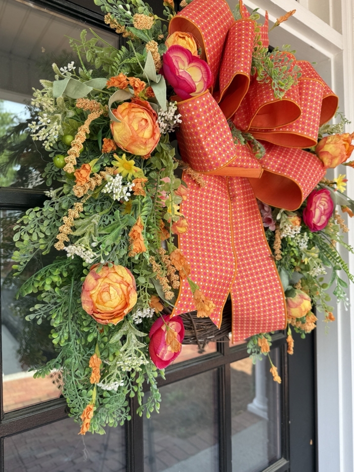 Angled view of luxury orange peony grapevine wreath on front door