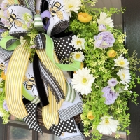 Side angle of luxury bee wreath with designer bow on black door