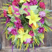 colorful pineapple wreath with bright tropical flowers and handmade bow on rustic door