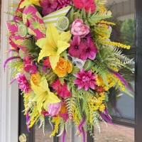close up of pineapple wreath showing tropical flowers citrus accents and handmade bow detail