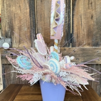 Side view of a handcrafted candy-themed centerpiece featuring glitter candy decorations, pastel lollipops, and sparkling lavender accents.