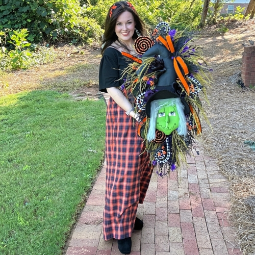 Designer handmade Halloween witch swag displayed by artist featuring black roses, orange velvet ribbon, purple florals, and whimsical details.